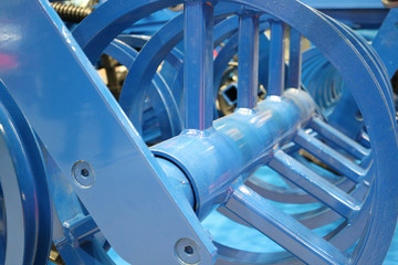The blue wheels of the cultivator are arranged in a row.