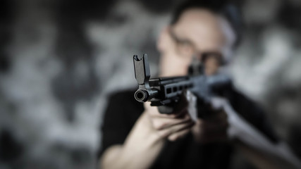 Man holding and preparing to shoot a 9mm carbine rifle. Personal defense concept