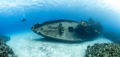 Fotobehang Schipbreuk Scuba divers examining the famous USS Kittiwake submarine wreck in the Grand Cayman Islands  © Martin Broen/Wirestock