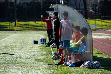 back view of a bench on a soccer field with young players waiting to go out and play © David Fuentes