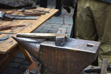 A hammer on an anvil, traditional tools for working with metal in a blacksmith shop. Handmade blacksmith.
