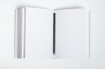 Mockup of closed blank square book and black pencil at white textured paper background