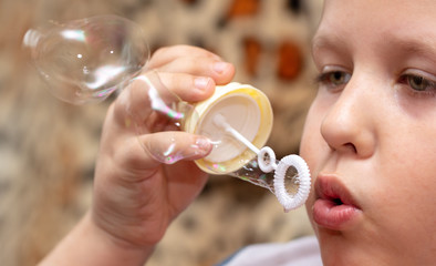 The boy blows up soap bubbles