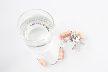 denture is cleaned in a glass of water. proper hygiene.