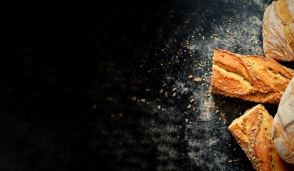 Assortment of bread. Baking on a dark background, top view, place for text. A variety of beautiful bread