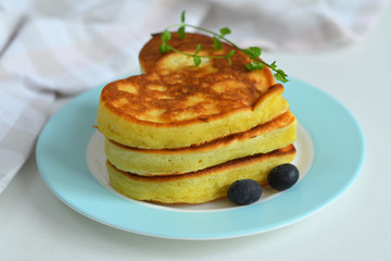 stack of pancakes with fruit, mint and blueberries.pancakes in the shape of a heart.