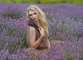  blonde girl in lavender field in summer enjoying vacation