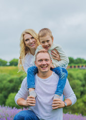  happy family with boy relax in lavender field in summer