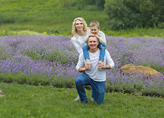 happy family with boy relax in lavender field in summer