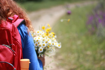 Girl walking in nature.Flowers in hand. In beautiful nature.