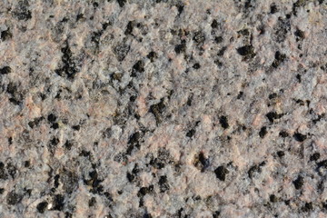 Close-up texture of white-pink granite with black splashes