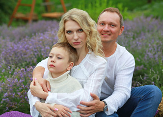  happy family with boy relax in lavender field in summer