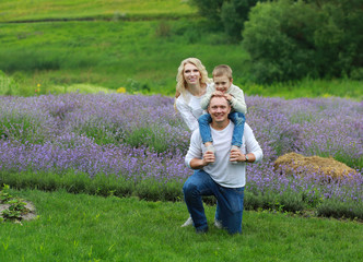  happy family with boy relax in lavender field in summer