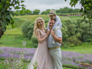  happy family with boy relax in lavender field in summer