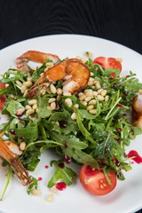 Green salad with shrimps: greens, arugula, tomato, pine nuts and sauce