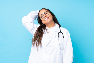 Young doctor woman over isolated blue background laughing