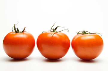 Fresh tomatoes. Red with a green spine. Vegetarian food. On white background