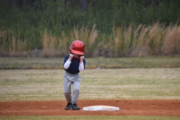 Baseball kid with batting helmet stuck on head