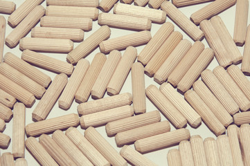 A bunch of chaotically located wooden dowels on white surface