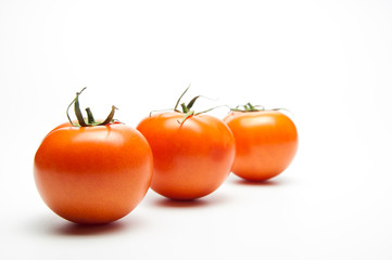 Fresh tomatoes. Red with a green spine. Vegetarian food. On white background