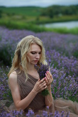  blonde girl in lavender field in summer enjoying vacation