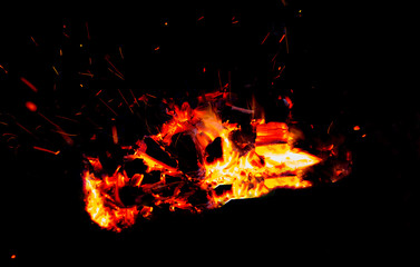 Fototapeta na wymiar Coals burning in the dark as a background