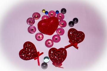 Hearts candles and glass balls on a pink background...