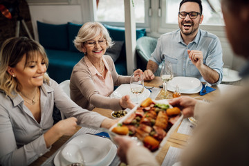 Happy family having lunch at dining table at home.