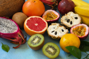 Fruit background. Assorted ripe juicy Exotic asia summer seasonal fruits on a blue stone background.