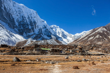 Himalayan lodges on the way to Tashi Lapcha pass. Village and pasture in Khumbu area in Nepal. Beautiful snowy mountains landscape.