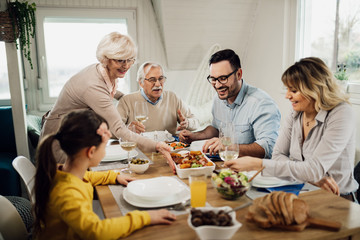 Happy multi-generation family enjoying in lunch at home.