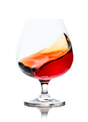 Splash of cognac in glass, isolated on white.