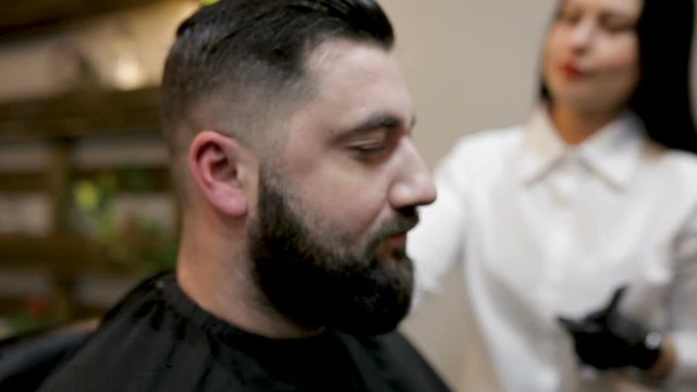 Preparing for the haircut. Bearded man comes to the barbershop