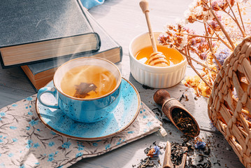tea and a book in the spring sunshine. near honey and flowers