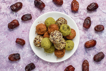 Homemade healthy vegan raw energy truffle balls with dates and walnuts,matcha powder,cocoa powder on light background