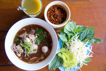 Boat  noodles,Thai style noodle soup or noodles with pork and pork balls, Close up or selective focus and garnish set for Thai Boat  noodles, chilly, sugar, vinegar.