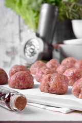 Raw meatballs on the piece of parchment ready to be cooked