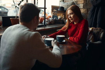 Couple in love enjoying yummy coffee in cafe. close up side view photo. friendship, love, affection, relationship