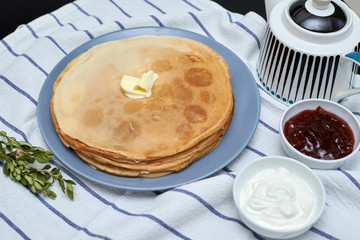 pancakes on a plate with butter, shrovetide, sour cream and jam