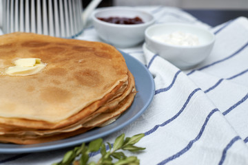 pancakes on a plate with butter, shrovetide, sour cream and jam