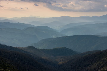 Misty spring mountain hills landscape. Layers of green mountains and hills in the haze during...