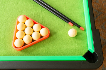 Cue with ball on green table for game of billiards