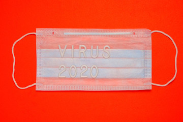 Medical mask for protection and the inscription virus 2020 on a red background.