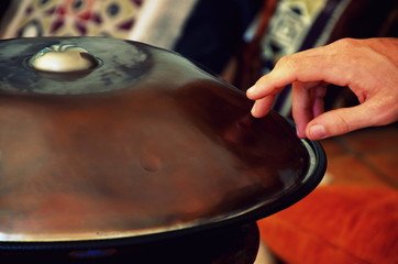 close up of a hand playing a handmade hang drum (hand pan) 