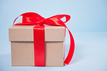 Gift box with red bow on the blue background. Copy space