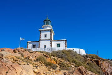 Fototapeta na wymiar Greek Lighthouse Building on Blue Sky Background