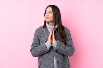 Young brunette woman over isolated pink background scheming something