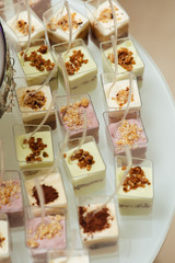 Delicious candy bar at luxury wedding reception. Exclusive expensive catering. Table with modern desserts, cupcakes, sweets. Space for text. Holiday celebration