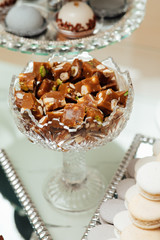 Delicious sweets on candy buffet. Candy bar on wedding ceremony with a lot of different candies. Details of a tasty candy bar of sweets, cookies , sweets concept.