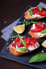 Trout Gravlax on the slices of white bread with ricotta topped with greenery on the stone platter. Nordic cuisine meal